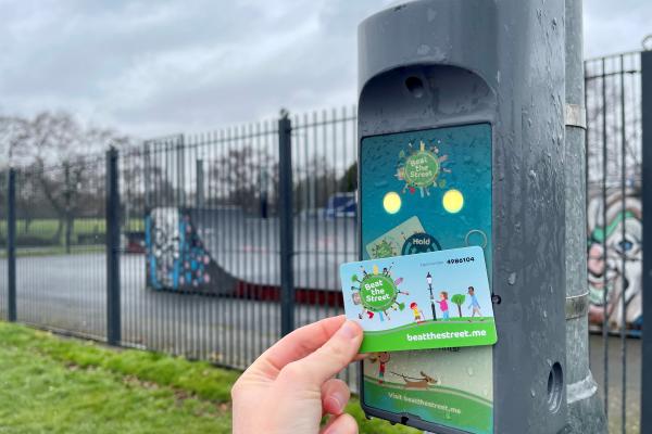 Image shows a Beat the Street card being tapped onto a Beat Box attached to a lamppost.
