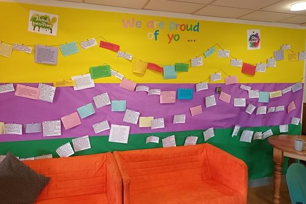 Social space at the TLC Hub with comfortable sofas and a colourful display wall.