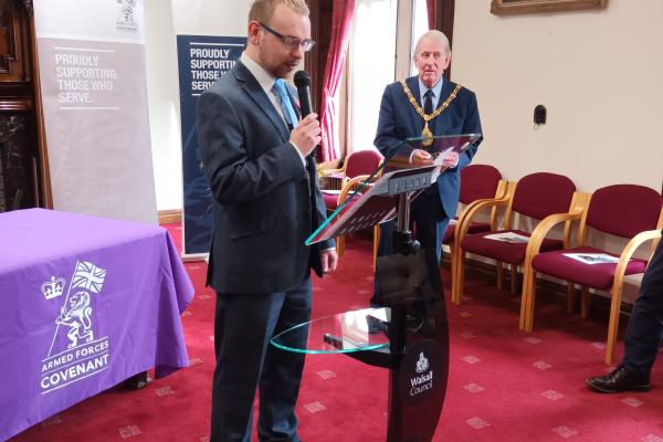 Image depicts Councillor Adam Hicken speaking at the front of the conference room at the Armed Forces Covenant Signing at the Council House in Walsall. 