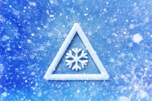 Image depicts a warning sign with a white snowflake against a blue and white background.
