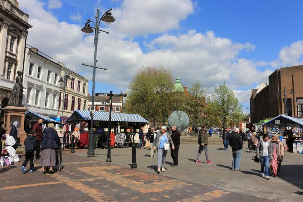 A busy market place in Walsall on a sunny day with blue skies