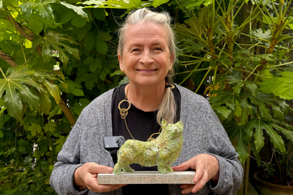 Artist Julie Edwards holding a model of a corgi