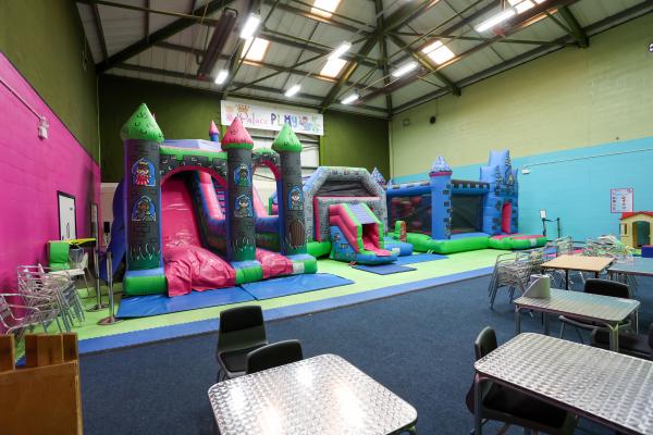 three bouncy castles in a sports hall