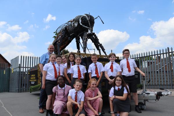 Group of children and teacher stood in front of Manchester Bee Monument