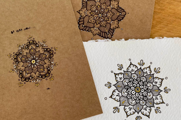 Three intricate mandalas drawn on card with pen.