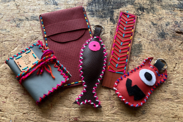 A variety of leather crafts offered at the Museum including a notebook, pencil pouch, fish keyring, bookmark and moster bag charm.