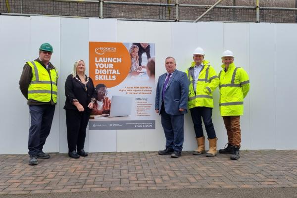 Councillor Andrew and delegates in front of advertising sign