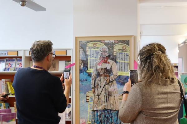 Two visitors taking photographs of the Sister Dora Collage