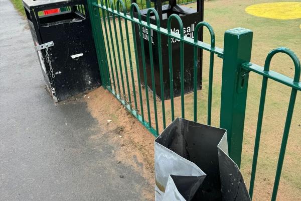 Image depicts sandbags used next to the play area fence and bins following arson damage.