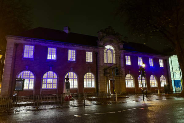 Image depicts the Lichfield Street Hub in Walsall lit up in blue at night.