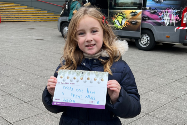 A girl holds her wish for walsall written on a card