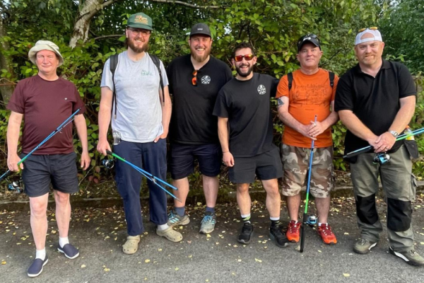 Image depicts six men in a group holding fishing equipment.