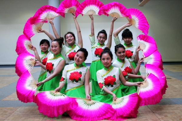 A group of performers posing with fans