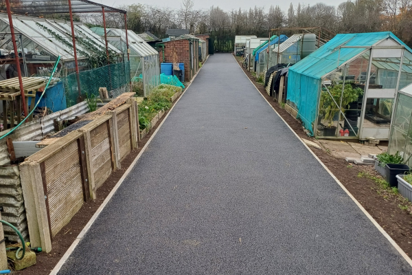 the same driveway after work has been done to dig up the track and lay down tarmac to create a smooth and accessible surface