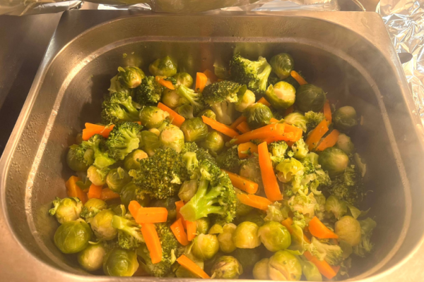 Image depicts a metal tray of mixed cooked vegetables.