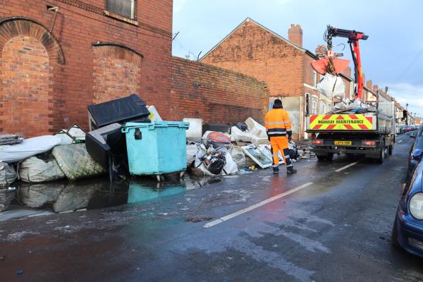 Crane lorry clearing waste from street