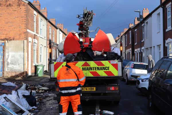 Crane lorry clearing waste from street