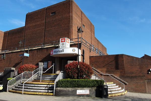 the entrance of a railway station with steps leading up to the door