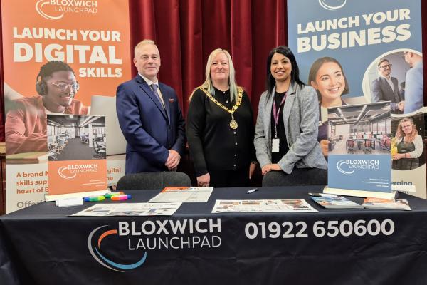 three people standing behind a Bloxwich Launchpad display table