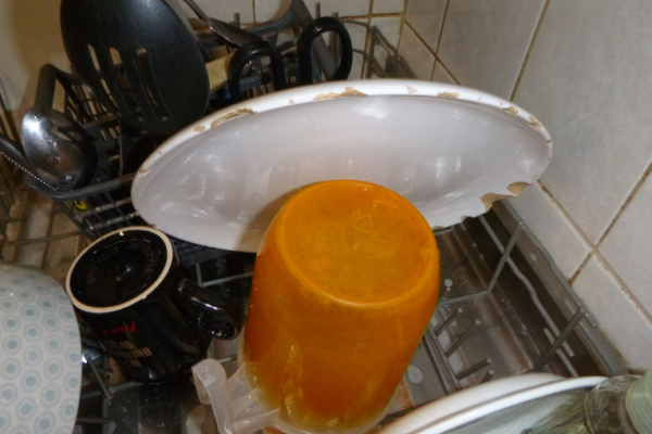 Image shows badly chipped plate on draining rack in kitchen.