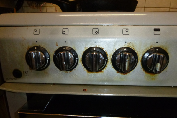 Image shows dirty cooker controls in kitchen.