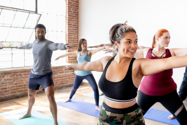 Image depicts a group of people taking part in yoga.