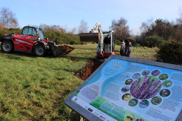 Purple Horizons Sign with diggers in background 