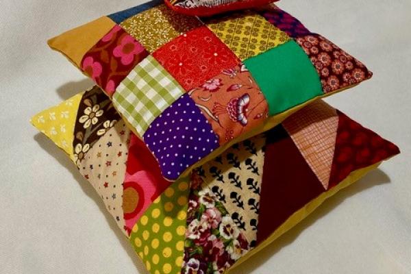 A pile of colourful patchwork fabric cushions