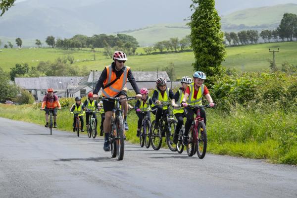 Bikeability - children cycling with instructor in the country side