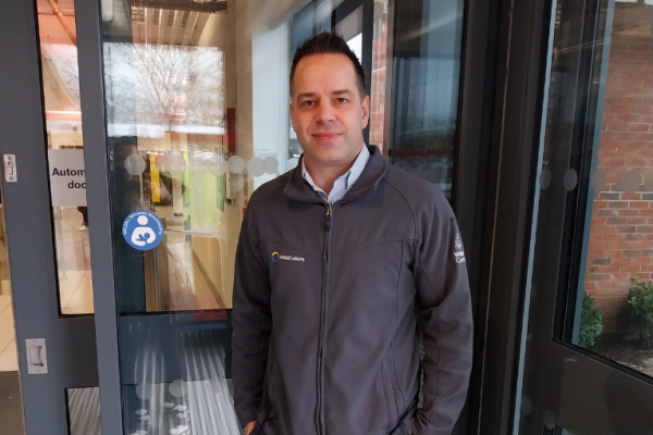 Image depicts a Walsall Leisure colleague next to a sticker for breastfeeding friendly scheme.