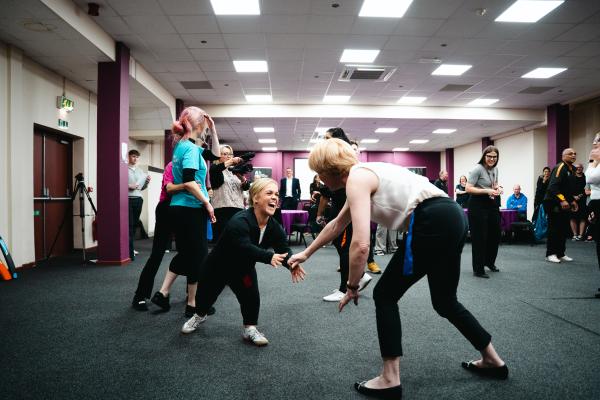 Image depicts Wendy Morton MP and Ellie Simmonds MBE taking part in a group exercise.