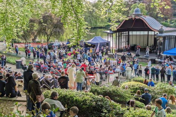 A large crowd watches a band at the bandstand in Walsall Arboretum