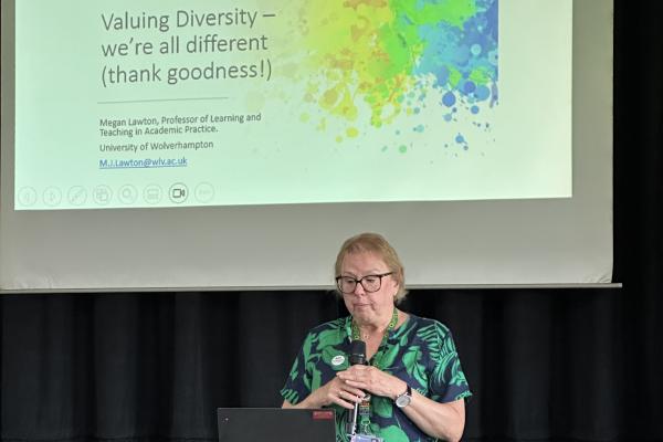 Image depicts Professor Megan Lawton giving a presentation at the Neurodiversity Conference.