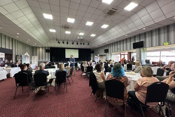 Image depicts a large room of conference attendees at Walsall Football Club.