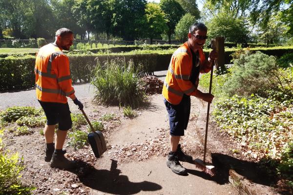 Two men doing ground work with gardening tools