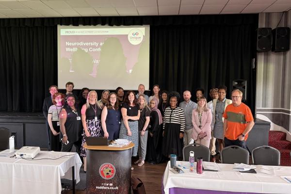 Image depicts a large group of attendees and speakers at the Neurodiversity and Wellbeing Conference.