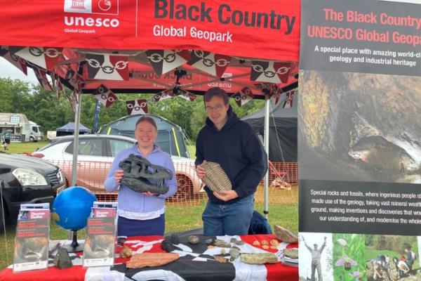 The Black Country Geopark team at their stall holding a dinosaur skull and trilobite