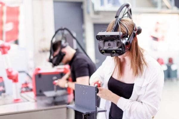 Two people wearing VR goggles and welding in an virtual reality environment