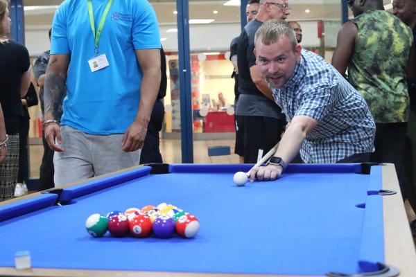 Councillor Hicken playing pool at the Our Place launch event on 30 June