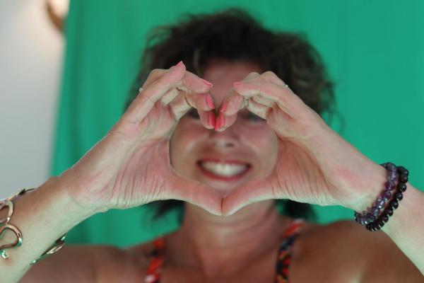 A woman holding her hands up in the shape of a heart