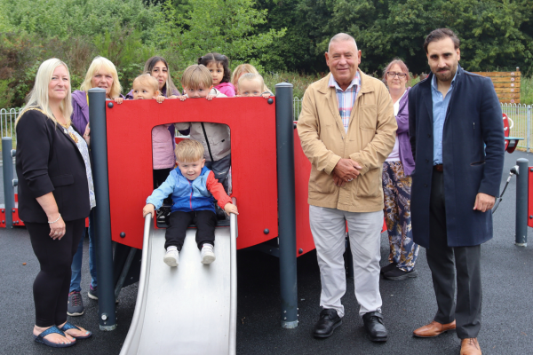 group picture on play area with child on slide
