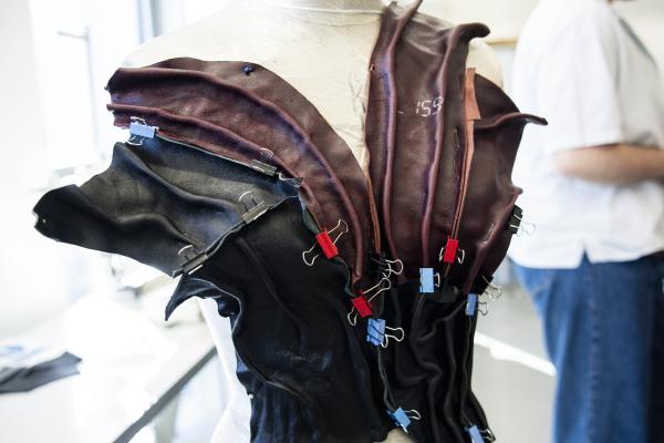 A mannequin with a leather garment pinned and clipped to it