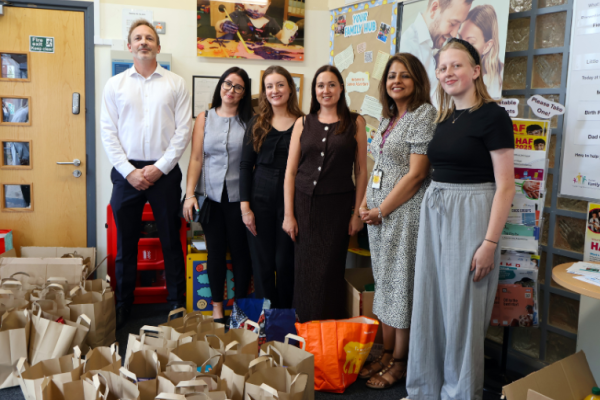 Image depicts employees from Opus and Walsall Council in front of food parcel bags.