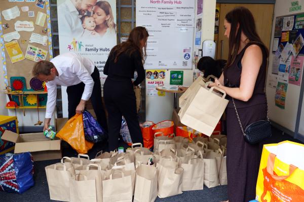 Image depicts employees from Opus packing food parcel bags.