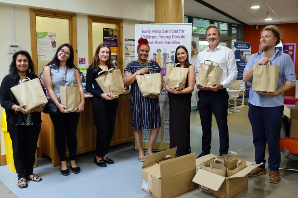 Image depicts employees from Opus and Walsall Council holding food parcel bags.